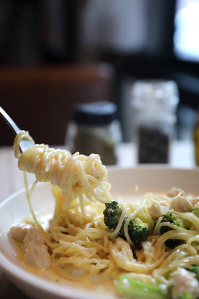 istock alfredo spaghetti broccoli chicken white sauce in restaurant background 1064599284