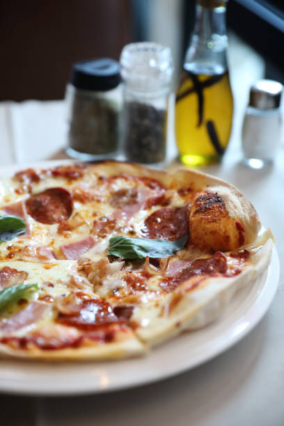 istock pepperoni bacon and ham pizza in restaurant background 1064599672