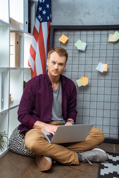 istock serious young male freelancer working on laptop in home office 1064600410