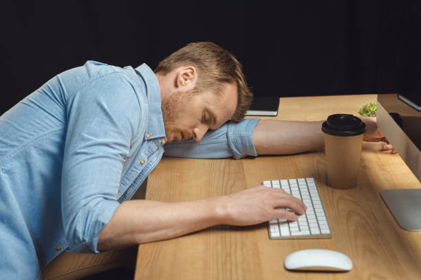 istock tired businessman sleeping at table with computer and paper coffee cup during night time in office 1064601996