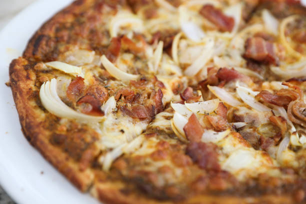 istock Pizza with crispy bacon onion on outdoor table 1064602668