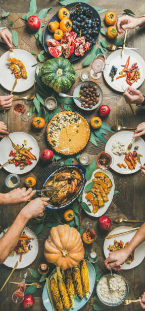 istock Friends feasting at Thanksgiving Day table with turkey, narrow composition 1064609826