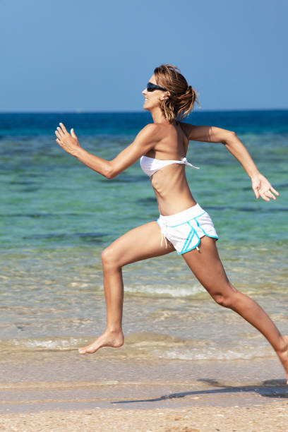 istock woman runing on the beach 1064616510