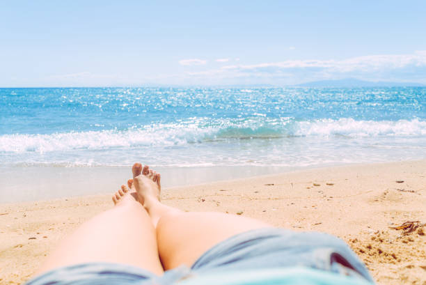 istock Female legs sunbathing on the beach 1064617348