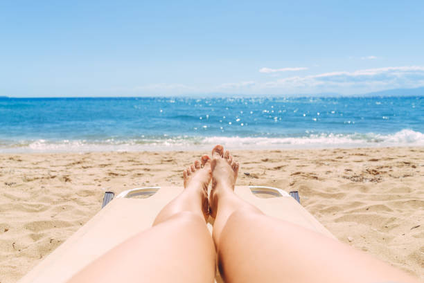 istock Female legs sunbathing on the beach 1064618156