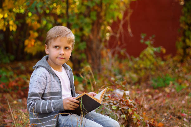 istock boy sitting in the woods on a log 1064627342