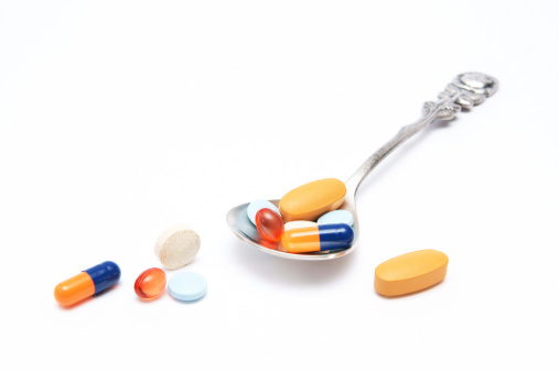 Colorful pills with a spoon