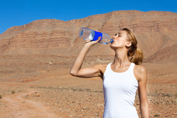 istock woman drinking water in the desert 1064630046