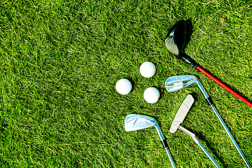 golf clubs and balls on grass