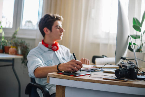istock Young teenage boy  - graphic designer at work 1064631332