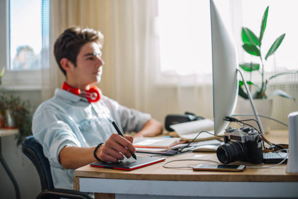 istock Young teenage boy  - graphic designer at work 1064631748