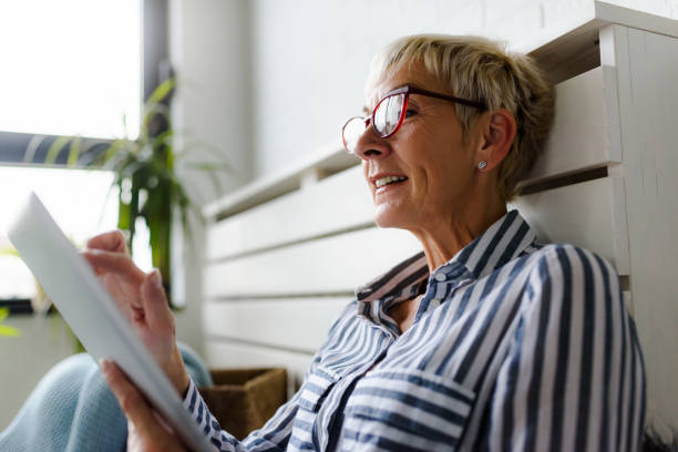 istock Smiling beautiful senior woman using digital tablet at home 1064632042