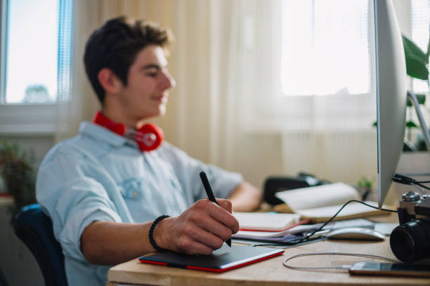istock Young teenage boy  - graphic designer at work 1064632080
