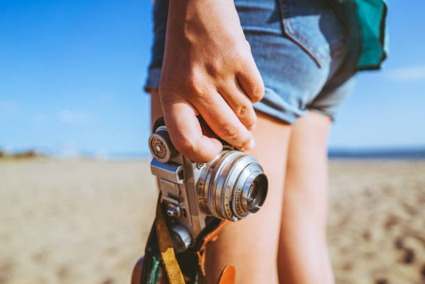 Woman with analog camera on the beach
