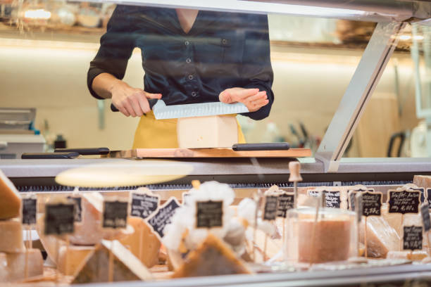 shop kontorist kvinna sortering ost i stormarknad displayen - cheese counter supermarket bildbanksfoton och bilder