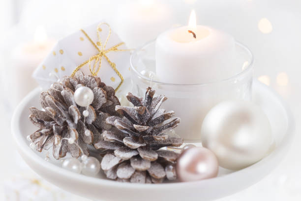 istock White candles with pine cones and baubles for Christmas 1064643152