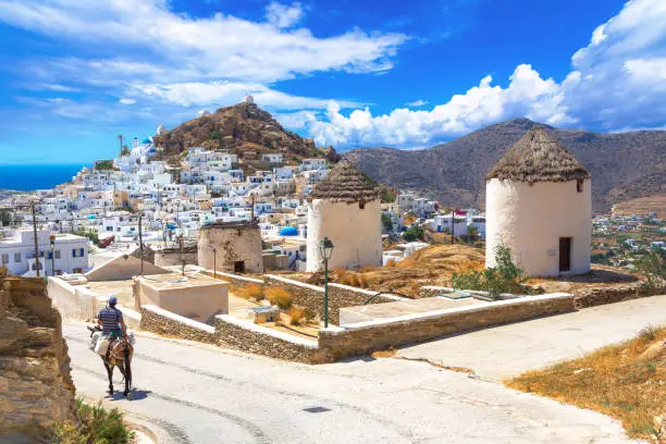 Photo of Traditional houses, wind mills, churches  and donkey in Ios island, Cyclades, Greece.