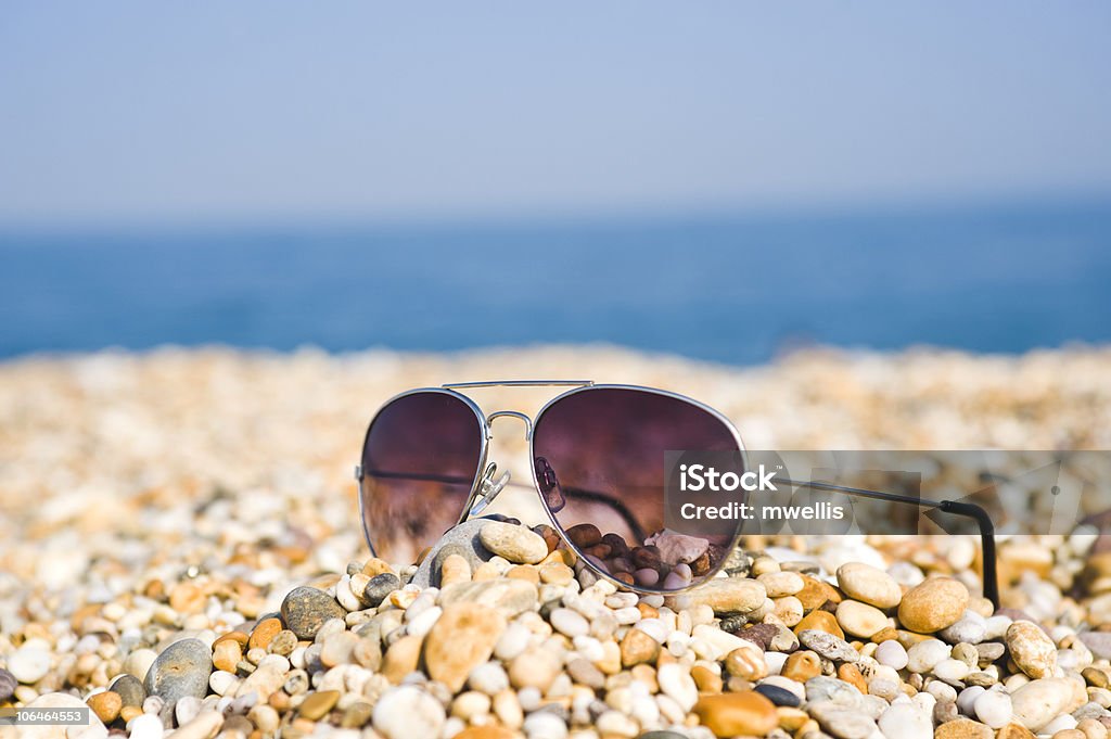 Paire de lunettes de soleil allongé sur la plage - Photo de Accessoire libre de droits