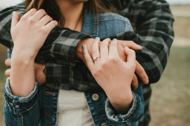 Man Hugging Woman with Engagement Ring Engaged couple embracing close up engagement stock pictures, royalty-free photos & images