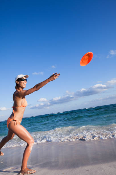 istock woman playing frisbee on the beach 1064655810