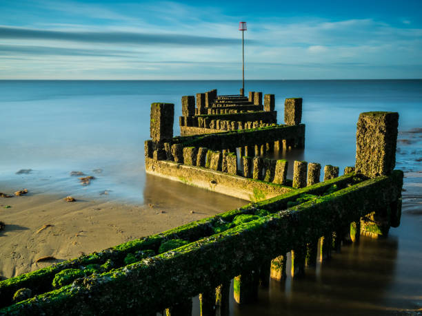 istock Long exposure wooden groyne at sunset 1064658900