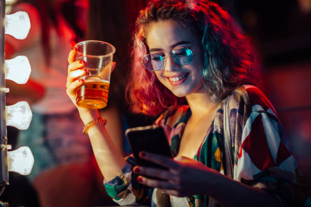 frau, trinken bier und mit handy - festival alcohol stock-fotos und bilder