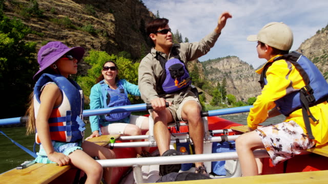 Young Caucasian parents children rafting Colorado River outdoors