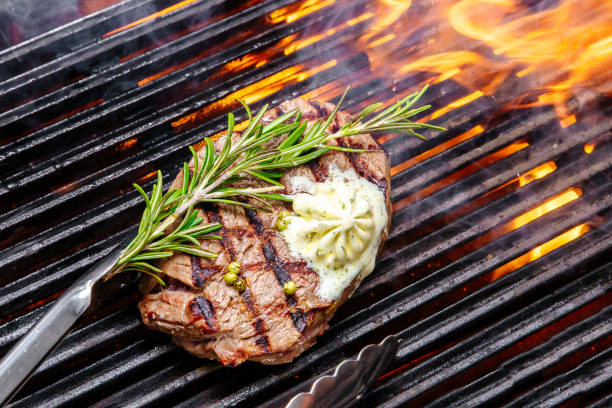 istock steak on a grill fire, with herbs and butter 1064665076
