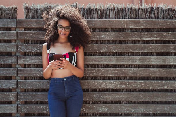 istock Charming smiling woman in eyeglasses with smartphone 1064665216