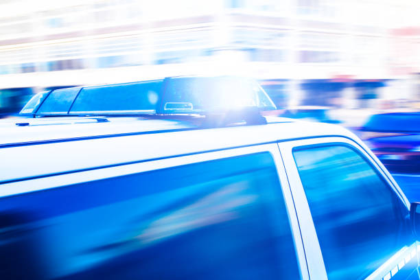 zbliżenie migających niebieskich świateł w samochodzie policyjnym - city street flash zdjęcia i obrazy z banku zdjęć