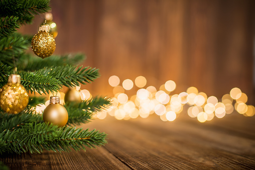 istock Abeto decorado con bolas de Navidad en madera rústica y de fondo luz de destellos 1064667638