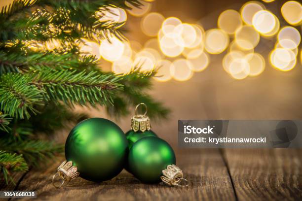 Fir Tree And Three Green Christmas Balls On Rustic Wood And Sparkles Light Backgorund Stock Photo - Download Image Now