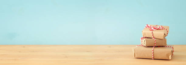 istock banner of handmade wrapped gift boxes over wooden table. 1064676996