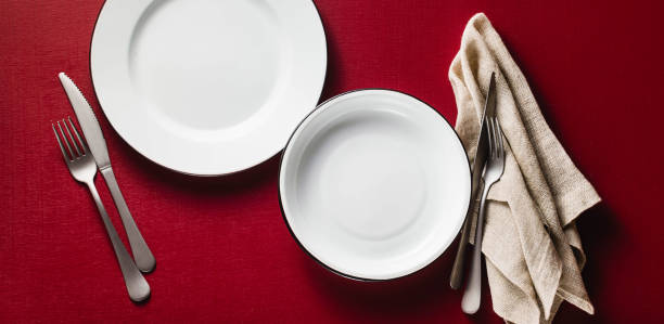 istock banner of empty dining table set for two. two aluminum plates on a raspberry table with napkins and cutlery. copy space 1064679170