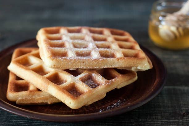 istock Viennese, Belgian waffles with honey on a white plate. 1064680554