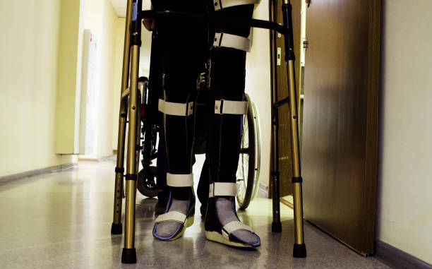 istock Legs of disabled man in orthosis walking with a walking frame 1064682802