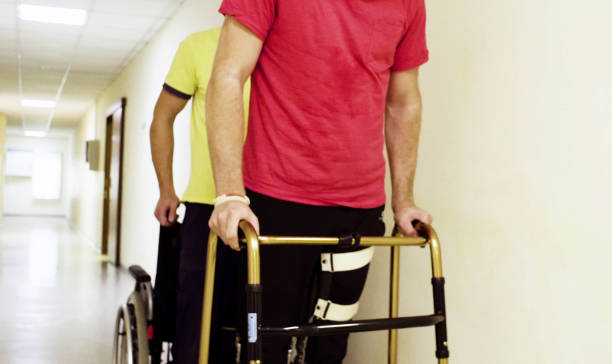 istock Disabled man in orthosis walking with a walking frame 1064682822