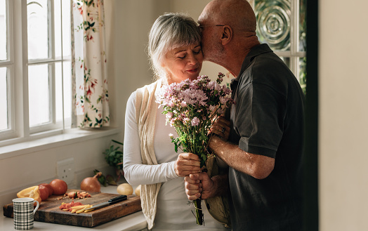 Romántica pareja senior en casa expresando su amor photo
