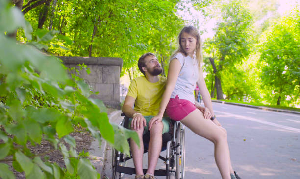 istock Young disable man on a walk in the park with his wife 1064685622