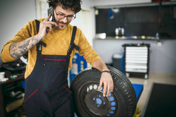 Handsome young repairman consulting about the problem in the car workshop