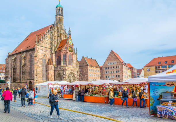 Nurnberg, Germany, April 12, 2017: People are strolling in front of the Frauenkirche during easter market in Nurnberg, Germany.