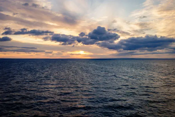 Photo of Travel by ferry in the Baltic Sea at sunrise with Sweden on the horizon. Taken from the Color Line Fantasy which is a cruise ferry between Kiel and Oslo.