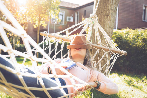 Young woman lying down and sleeping on a hammock stock photo