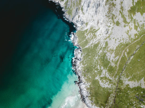Aerial view of turquoise Kvalvika beach in the Arctic on Lofoten Islandsin Norway Drone photo of beautiful remote textured water beach in Northern Norway lofoten photos stock pictures, royalty-free photos & images