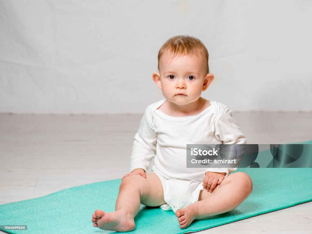 Altijd Phalanx klep The Baby Is Performing Physical Exercises On The Yoga Mat Baby Yoga Stock  Photo - Download Image Now - iStock