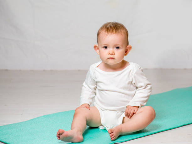 dziecko wykonuje ćwiczenia fizyczne na macie do jogi. joga dla niemowląt - male body sport exercising zdjęcia i obrazy z banku zdjęć