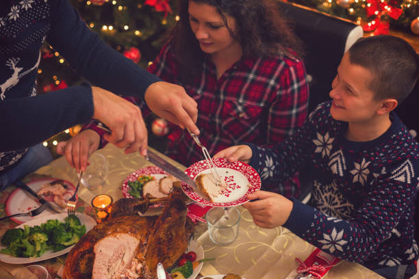 istock Young father carving stuffed roasted turkey for Christmas dinner 1064699870