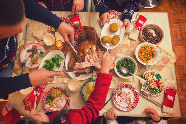 młody ojciec rzeźbienia nadziewane pieczone indyka na kolację bożego narodzenia - roast turkey turkey cutting roasted zdjęcia i obrazy z banku zdjęć