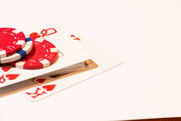 Poker cards and chips Two red and a white poker chip on a deck where the queen of hearts and the king of hearts is showing up wsop stock pictures, royalty-free photos & images