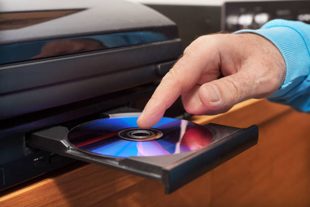 istock Hand holding DVD inserting to video player 1064703950